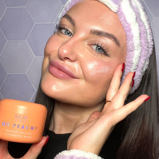a woman holding a jar of face cream