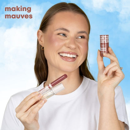 a woman holding a tube of lipstick