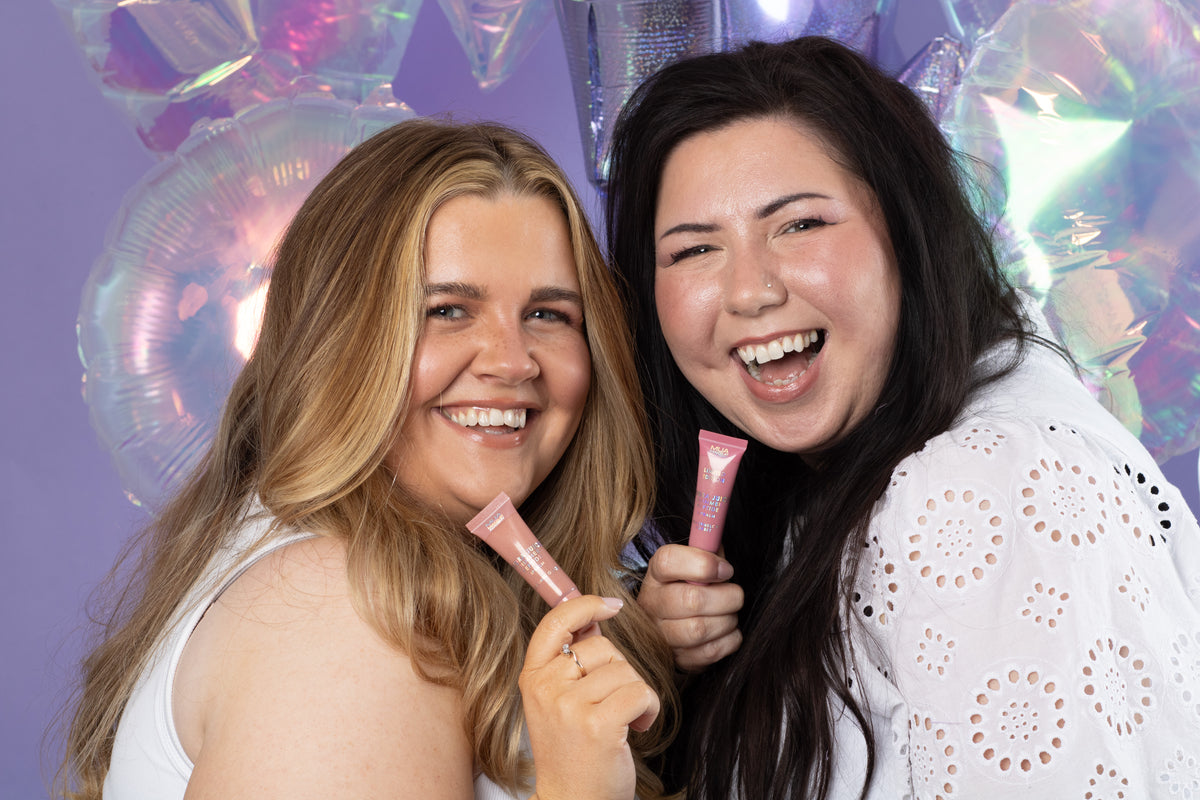 two women holding up small objects