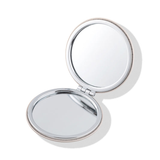 a small round mirror with a silver frame