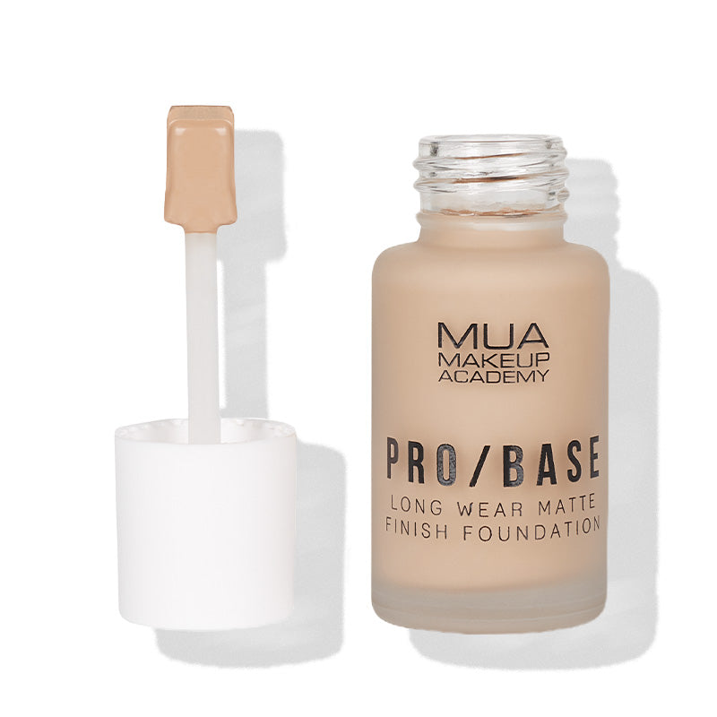 a bottle of makeup foundation with a brush
