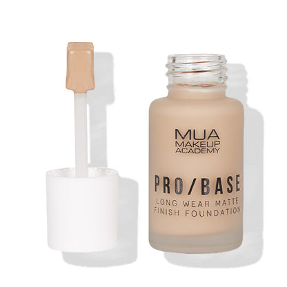 a bottle of makeup foundation with a brush