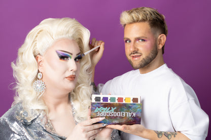 a man holding a brush and a woman with a makeup brush