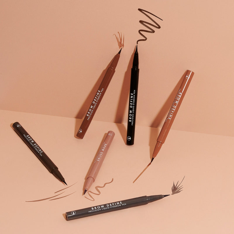a group of eyeliners on a pink surface