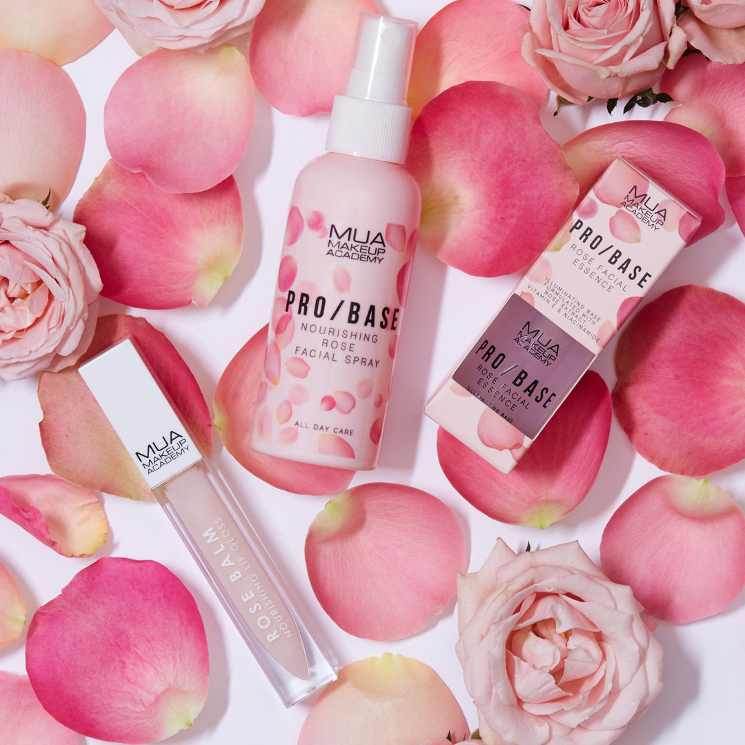 a group of pink roses and bottles of cosmetics
